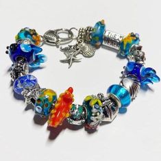 This hand-made, one-of-a-kind, Pandora compatible Murano glass bead hand-made bracelet would make a wonderful gift for yourself or someone special AND it comes in a gift box!  It's on a strong durable silver tone metal snake chain and consists of a combination of high-quality Murano glass lampwork, faceted, foil, and/or solid color glass, or artisan beads, and silver-tone metal rhinestone, crystal, flower, and/or decorative theme spacer beads.  NOTICE the Hawaii Shirt bead! Please refer to the p Artistic Colorful Beads Jewelry Gift, Silver Glass Beaded Bracelets For Gifts, Nickel-free Beaded Bracelets As Gift, Adjustable Glass Beaded Bracelets As Gift, Glass Beaded Jewelry For Gifts, Turquoise Beaded Bracelets With Charms As Gift, Glass Round Beads For Gifts, Unique Bracelets With Spacer Beads For Gift, Round Glass Beaded Bracelets As Gift