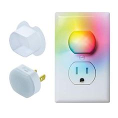 an electrical outlet with a colorful light on the cover and two white plugs next to it