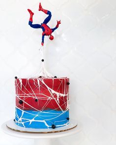 a spiderman cake is decorated with red, white and blue icing