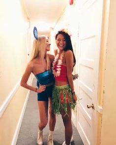 two women dressed up in costumes standing next to each other on the hallway between doors