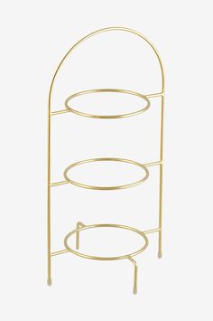 a three tiered gold metal rack with plates on the top and bottom, against a white background