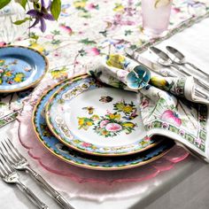 a table set with plates, silverware and napkins on top of each other