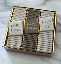 three business cards in a gold box on a marble counter top, with the name james laya printed on them