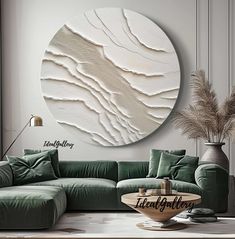 a living room with green couches and a large circular wall art piece on the wall