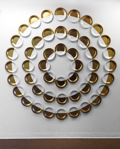 a white and gold circular sculpture on the wall