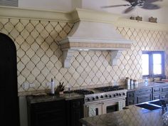 a kitchen with an oven, range and ceiling fan in it's center area