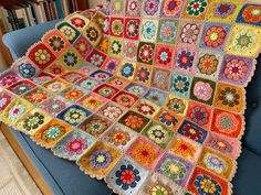 a crocheted granny blanket is sitting on a couch