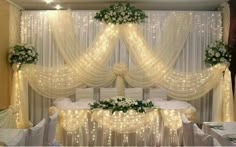 a bed covered in white curtains and lights