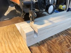 a piece of wood is being worked on with a circular sawtoothing machine in the background