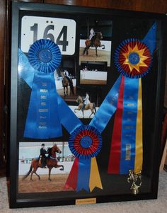 a framed photo with ribbons and horses on it