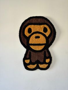 a monkey shaped door mat hanging on the side of a wall with a white background