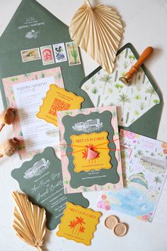 the wedding stationery is laid out on top of the envelopes and other items