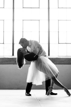 a man and woman dance together in an empty room