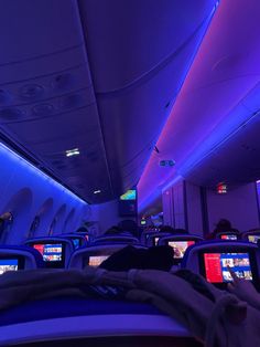 the inside of an airplane with many monitors and people watching them on their laptops