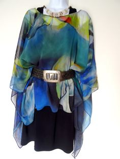 "Water Lily Art Cape - Sheer Silk Poncho - Blue Silk Cover Up - Sheer Caftan - Plus Clothing Wear it long, Tie it on the side. Tie it in the back. BELT IT! Enjoy the many ways you can wear your silk poncho. This is a continuous pattern. Each wearable varies slightly as the pattern may adjust for different placements. Color - Blue, Green, Black Material - Sheer Silk Georgette, Gauzy texture SIZE - One Size, Plus - Measures approx. -Front & Back - 24\" long from neck to lower hem on both sides Blue Poncho For Spring Vacation, Blue Poncho For Vacation In Spring, Spring Vacation Blue Poncho, Blue Poncho For Beach In Spring, Blue Bohemian Poncho For Spring, Spring Blue Bohemian Poncho, Water Lily Art, Silk Poncho, Cute Church Outfits