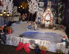 a christmas village scene with people and trees