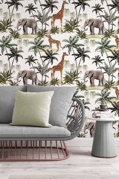 an elephant and giraffe wallpaper in a living room with a grey couch