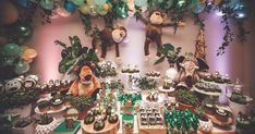 a jungle themed birthday party with balloons, decorations and stuffed animals on the wall above