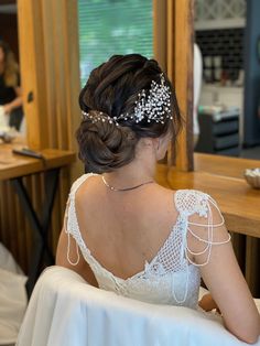 the back of a woman's head wearing a bridal hair piece with pearls on it