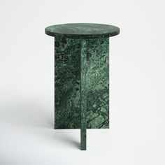 a green marble side table sitting on top of a white floor