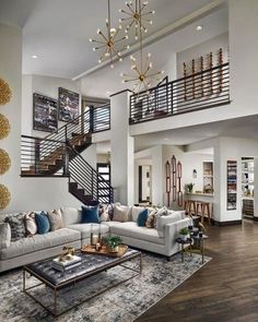 a living room filled with lots of furniture and a stair case in the middle of it