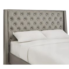 an upholstered headboard with white sheets and silver grey trimmings on it