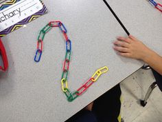 a person is holding a bookmark and some paper clips on a table with a name tag