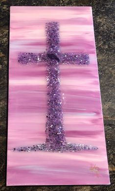 a cross made out of purple and silver glitters