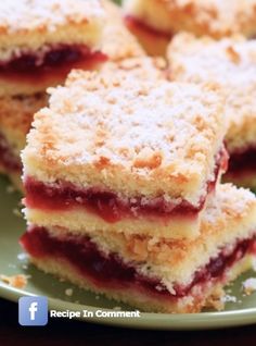 several pieces of cake on a plate with powdered sugar and jelly toppings in the middle