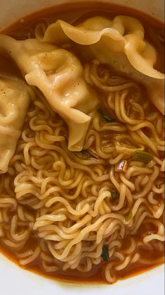 a bowl filled with noodles and sauce on top of a table