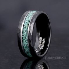 a wedding band with green and black beads inlayed to it's center