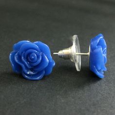 A set of bright royal blue colored resin roses decorate silver plated stud earrings (no nickel) in this pair of handmade earrings that also come with a matching set of silver plated earring backs. Size: 14mm roses These earrings are available in a variety of colors! http://etsy.me/1rv1YFV They are also available as dangle earrings! Bronze - https://www.etsy.com/stumblingonsainthood/listing/106361809 Silver - https://www.etsy.com/stumblingonsainthood/listing/113486696 If you would like to order a Blue Flower-shaped Resin Earrings, Blue Flower Earrings, Earrings Flower, Silver Stud Earrings, Flower Jewelry, Earrings Blue, Rose Earrings, Blue Rose, Blue Flower