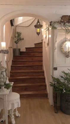 an entry way with stairs and potted plants