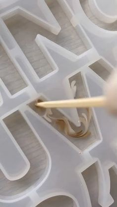 a close up of a person holding a toothbrush in front of some type of letters