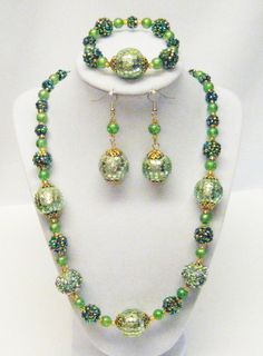 "Assorted Green Chunky Acrylic Bead w/Gold Findings Necklace/Bracelet/Earrings Set This necklace set is made with an assortment of large green acrylic beads and 8mm green glass beads, gold plated bead caps, and gold silver lined glass seed beads strung on flexible beading wire. It is 24\" in length and fastens with gold plated lobster clasp. It comes with bracelet and earrings that hang from gold fish hook ear wires.  Necklace Length: 24\"  Earrings Length: 2 ¾\" (including ear wire) Bracelet Le Green Multi-strand Beads For Jewelry Making, Handmade Green Multi-strand Beaded Necklace, Green Multi-strand Beaded Necklace With Large Beads, Green Multi-strand Beaded Necklace, Green Multi-strand Polished Beaded Necklace, Silver Line, Wire Bracelet, Bead Caps, Acrylic Beads