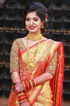 a woman in an orange and gold sari