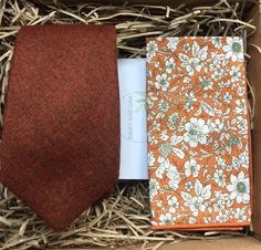 an orange tie and notepad in a box