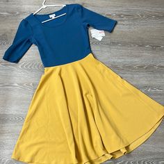 Brand New, Never Been Worn Nicole Style Dress From Lularoe. Blue On Top, Mustard/Gold On Bottom. Perfect For College Colors. Skirt Is Flowy, Body And Sleeves Are Fitted So It Is A Very Tight Fit. Recommend Going Up A Size. Size S. (Not True To Size) Blue Fitted Modest Midi Dress, Gold Midi Dress, Space Dress, College Colors, Lularoe Amelia Dress, Lularoe Nicole Dress, Yellow Floral Dress, Jersey Knit Dress, Amelia Dress