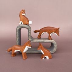 three wooden toy foxes sitting on top of each other