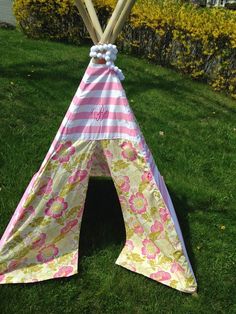 a teepee is sitting in the grass with two wooden sticks sticking out of it