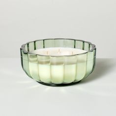 a green glass candle holder sitting on top of a table