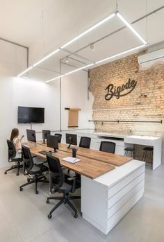 an office with desks and chairs in front of a brick wall that reads blyde