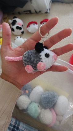 a hand holding a small stuffed animal keychain