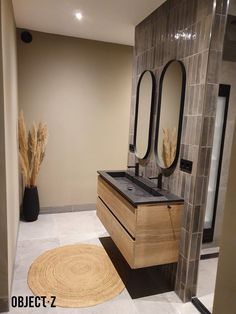 a bathroom with two sinks and mirrors on the wall next to a rug in front of it