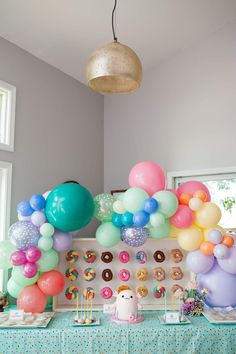 a table topped with donuts and balloons