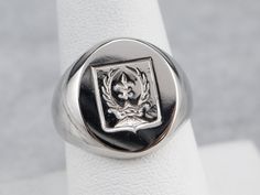 This signet ring is heavy and impressive! Crafted of luxurious platinum, this ring depicts a fleur de lis, crown, and laurel wreath emblem that is carved with great detail. Please note that this signet ring has its original monogram, and unfortunately, this piece cannot be altered without affecting the quality of the piece. Please feel free to contact us to help you find your perfect signet ring in your style and budget! Metal: Platinum Top Measurements: 14 x 16 mm, Oval Ring Size: 8 Marks: "PLA Classic Polished Signet Ring For Commemoration, Classic Coat Of Arms Ring, Classic Signet Ring With Coat Of Arms For Anniversary, Classic Signet Ring For Commemoration, Classic Formal Rings With Engraved Logo, Formal Signet Ring With Coat Of Arms, Luxury Engraved Ring With Polished Finish For Commemoration, Luxury Engraved Ring For Commemoration With Polished Finish, Classic Formal Rings With Coat Of Arms