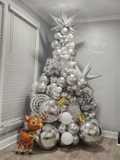 a christmas tree made out of silver and white ornaments in the corner of a room