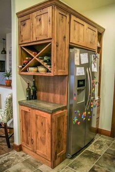 a refrigerator freezer sitting inside of a kitchen next to a wooden cabinet and counter