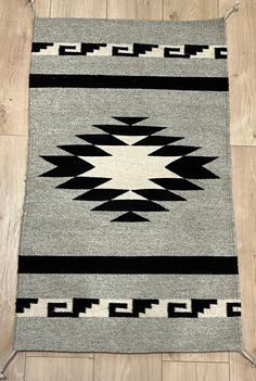 a black and white rug sitting on top of a wooden floor