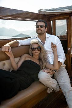 a man and woman sitting on the back of a boat